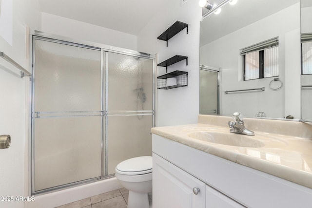 bathroom with vanity, toilet, a shower with door, and tile patterned flooring