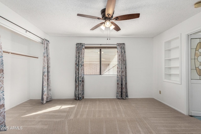 unfurnished bedroom featuring ceiling fan, light colored carpet, and a textured ceiling