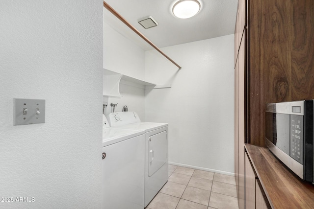 washroom with washer and dryer and light tile patterned flooring