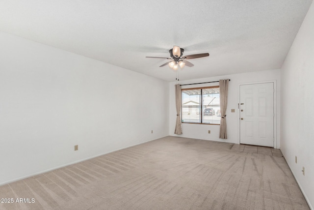 carpeted spare room featuring a textured ceiling and ceiling fan