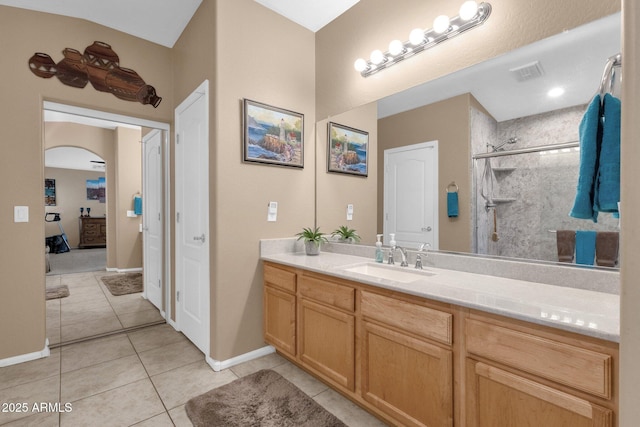 bathroom with vanity, tile patterned flooring, and a tile shower