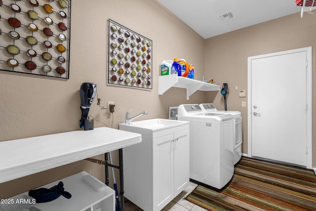 laundry area featuring cabinets, sink, and washing machine and dryer