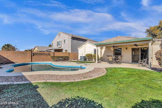 view of swimming pool featuring ceiling fan, a yard, and a patio