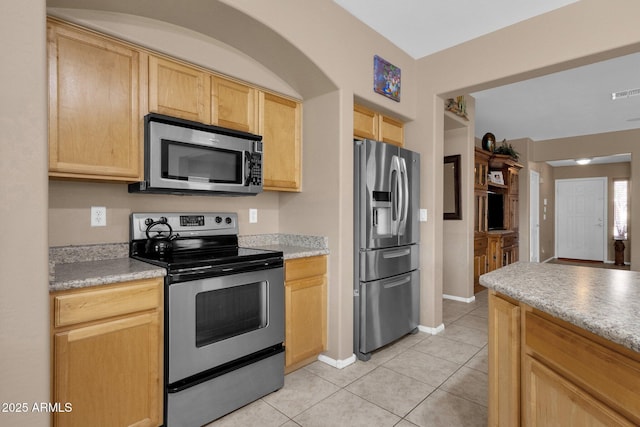 kitchen featuring light brown cabinetry, light tile patterned flooring, and appliances with stainless steel finishes