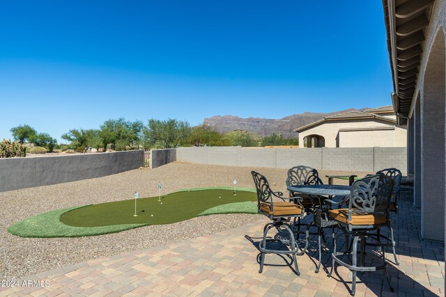 4126 S Last Chance Trl, Gold Canyon, AZ 85118 - view of patio with a putting area, a mountain view, and a fenced backyard