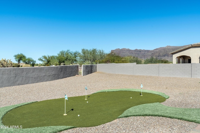 4126 S Last Chance Trl, Gold Canyon, AZ 85118 - surrounding community with a putting area, a mountain view, and a fenced backyard