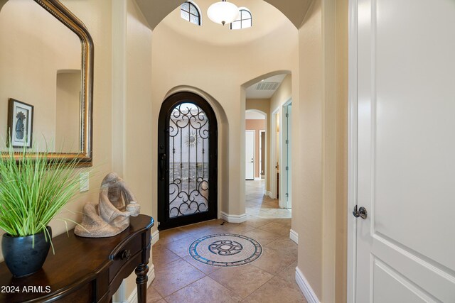 4126 S Last Chance Trl, Gold Canyon, AZ 85118 - foyer entrance featuring arched walkways, plenty of natural light, baseboards, a towering ceiling, and light tile patterned floors
