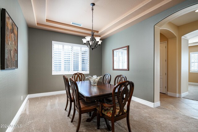 4126 S Last Chance Trl, Gold Canyon, AZ 85118 - dining room featuring light carpet, arched walkways, a chandelier, a raised ceiling, and baseboards