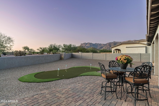 4126 S Last Chance Trl, Gold Canyon, AZ 85118 - view of patio / terrace featuring a putting area, a fenced backyard, and a mountain view