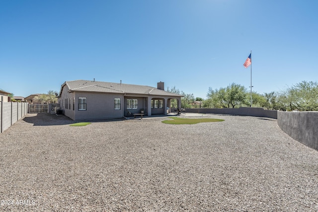4126 S Last Chance Trl, Gold Canyon, AZ 85118 - back of property with a chimney, a fenced backyard, and a patio