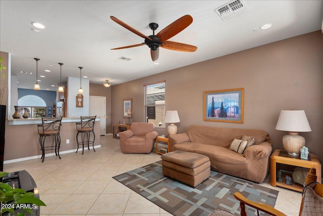 tiled living room featuring bar area, ceiling fan, and a healthy amount of sunlight