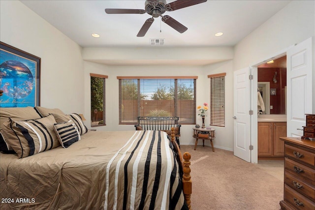 bedroom with ensuite bath, ceiling fan, and light colored carpet