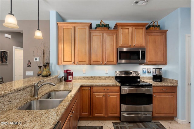 kitchen featuring hanging light fixtures, light tile patterned flooring, sink, and appliances with stainless steel finishes