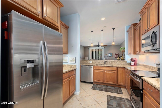 kitchen with light tile patterned flooring, appliances with stainless steel finishes, decorative light fixtures, sink, and kitchen peninsula