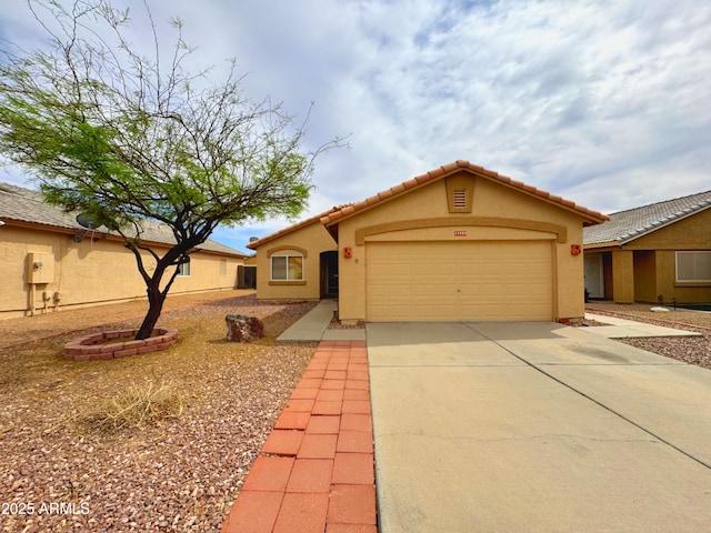view of front facade featuring a tiled roof, driveway, stucco siding, and an attached garage