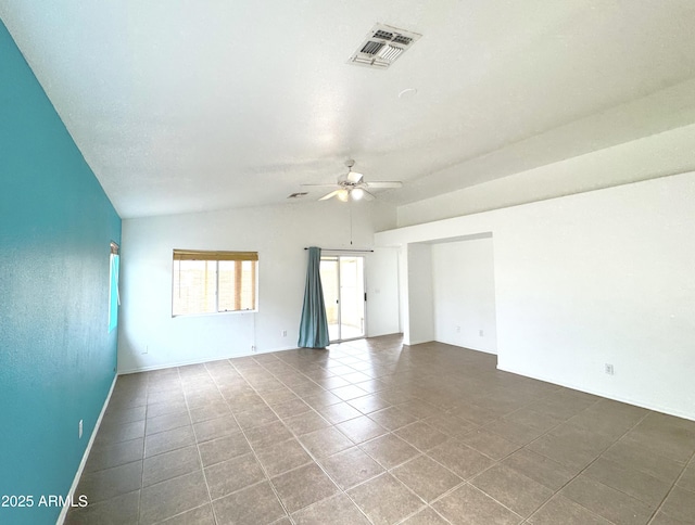 empty room with tile patterned floors, visible vents, vaulted ceiling, and a ceiling fan