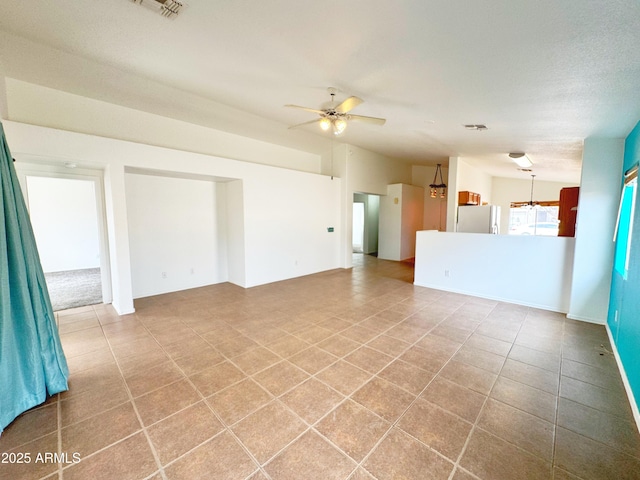 unfurnished living room featuring tile patterned floors, a ceiling fan, and visible vents