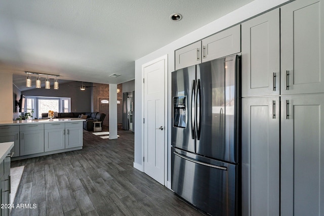 kitchen featuring lofted ceiling, light countertops, dark wood-type flooring, open floor plan, and stainless steel fridge with ice dispenser