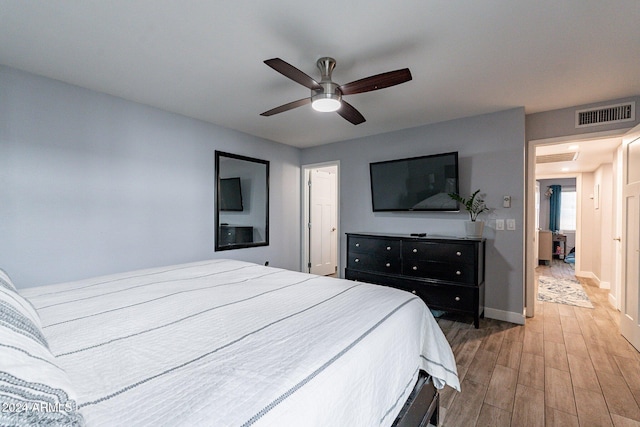 bedroom featuring baseboards, visible vents, ceiling fan, and wood finished floors