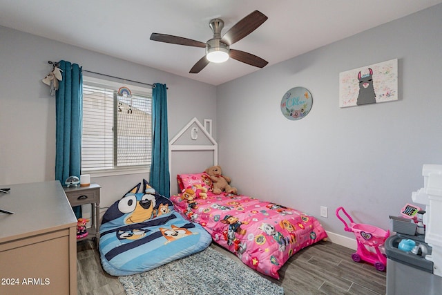 bedroom with ceiling fan, baseboards, and wood finished floors