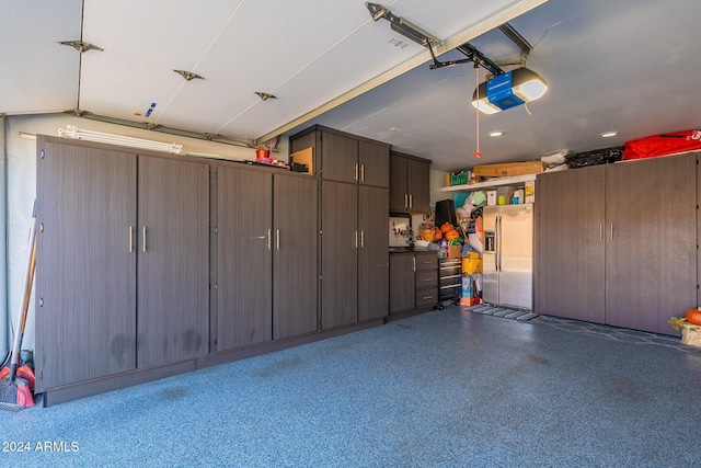 garage with stainless steel fridge and a garage door opener