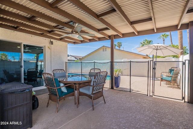 view of patio with outdoor dining space, ceiling fan, and fence