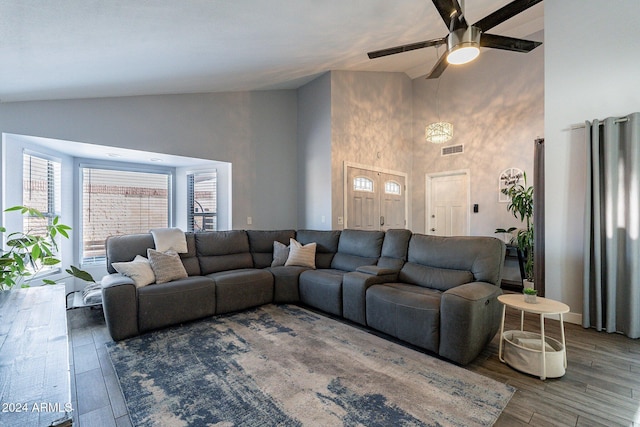 living area featuring high vaulted ceiling, a ceiling fan, visible vents, and wood finished floors