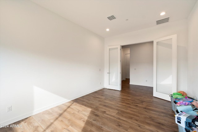 unfurnished bedroom featuring french doors and dark hardwood / wood-style floors