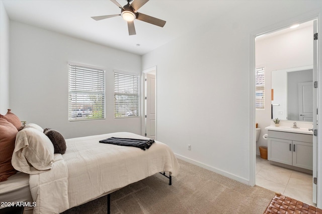 bedroom featuring ceiling fan, light tile patterned floors, sink, and connected bathroom