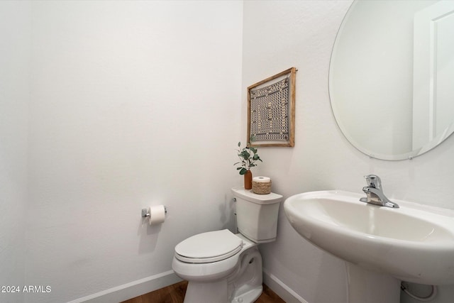 bathroom with hardwood / wood-style floors, toilet, and sink