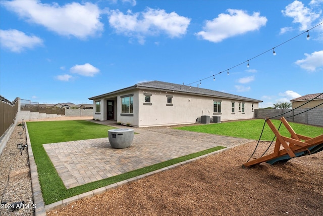 rear view of property with a lawn, a patio area, and cooling unit