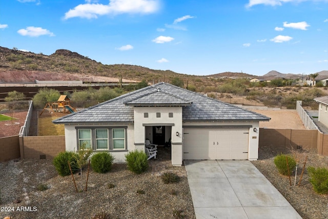 view of front of property with a mountain view, a garage, and a playground