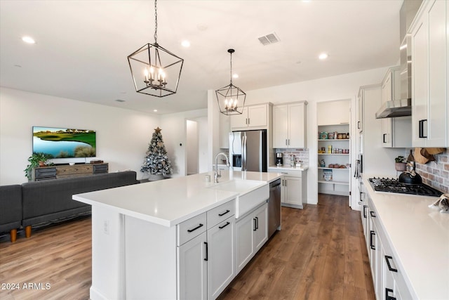 kitchen featuring hanging light fixtures, tasteful backsplash, dark hardwood / wood-style flooring, a kitchen island with sink, and appliances with stainless steel finishes