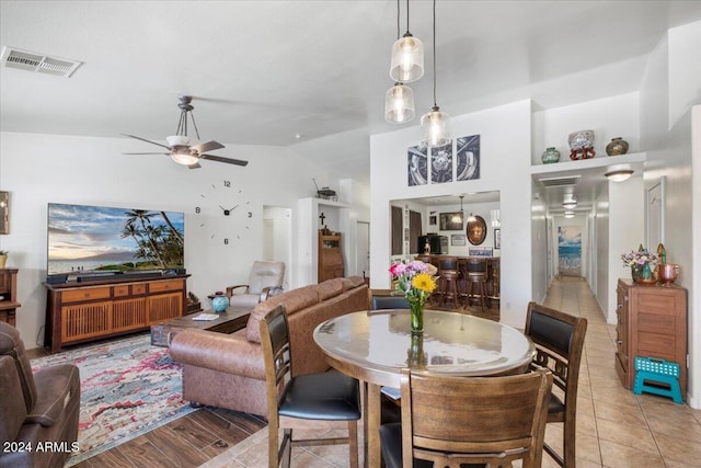 dining area featuring ceiling fan, light wood-type flooring, and lofted ceiling