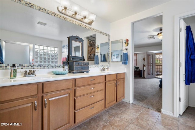 bathroom featuring tasteful backsplash, ceiling fan, vanity, and a healthy amount of sunlight