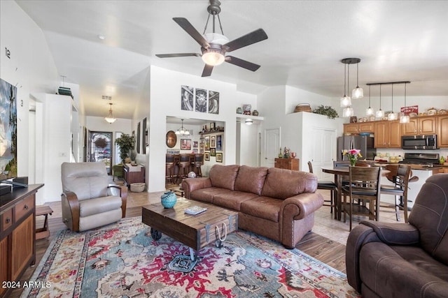 living room with light hardwood / wood-style floors, high vaulted ceiling, and ceiling fan