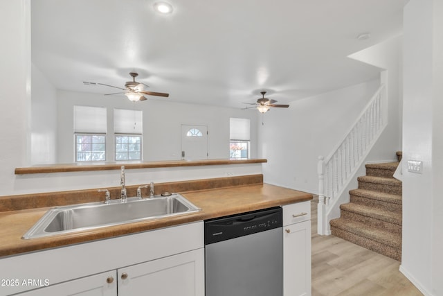 kitchen featuring a wealth of natural light, white cabinetry, a sink, and stainless steel dishwasher