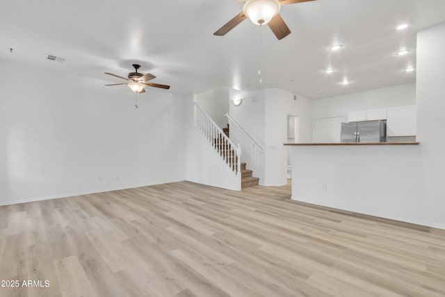 unfurnished living room with light wood finished floors, recessed lighting, visible vents, a ceiling fan, and stairs