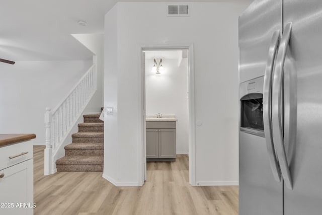 interior space with baseboards, visible vents, and wood finished floors