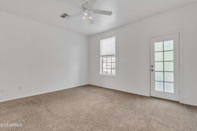 carpeted spare room with a ceiling fan and visible vents