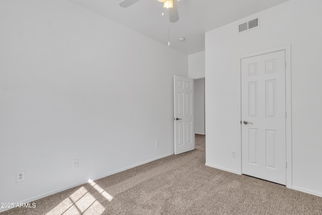 unfurnished bedroom with baseboards, a ceiling fan, visible vents, and light colored carpet