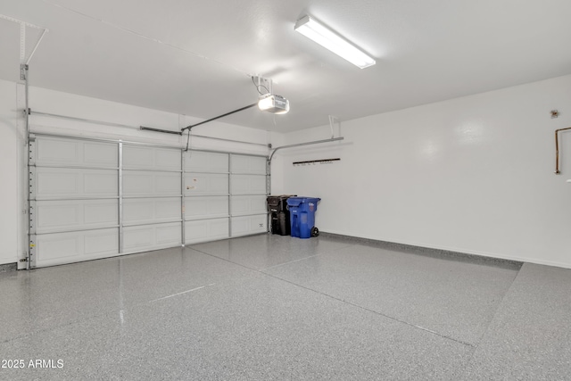 garage with baseboards and a garage door opener