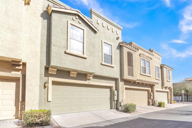 multi unit property with a garage and stucco siding