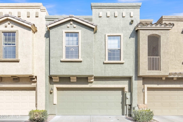 multi unit property featuring driveway, a tiled roof, an attached garage, and stucco siding