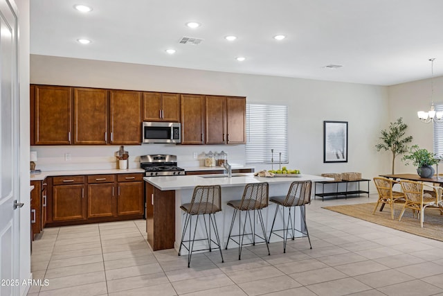 8027 W Northview Ave, Glendale, AZ 85303 - kitchen with appliances with stainless steel finishes, a kitchen breakfast bar, light countertops, a center island with sink, and light tile patterned floors