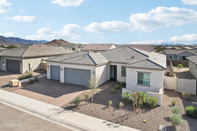 ranch-style home featuring a garage and a mountain view