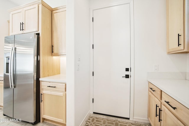 kitchen featuring stainless steel refrigerator with ice dispenser and light brown cabinetry