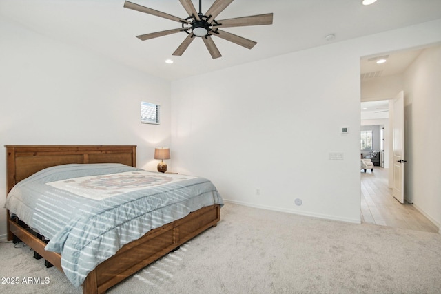 bedroom featuring multiple windows, light carpet, and ceiling fan