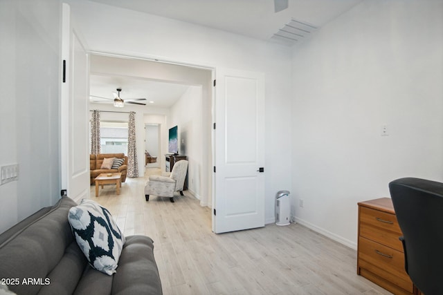 living room featuring ceiling fan and light hardwood / wood-style floors