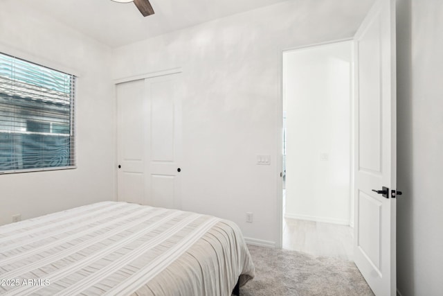 carpeted bedroom featuring ceiling fan and a closet